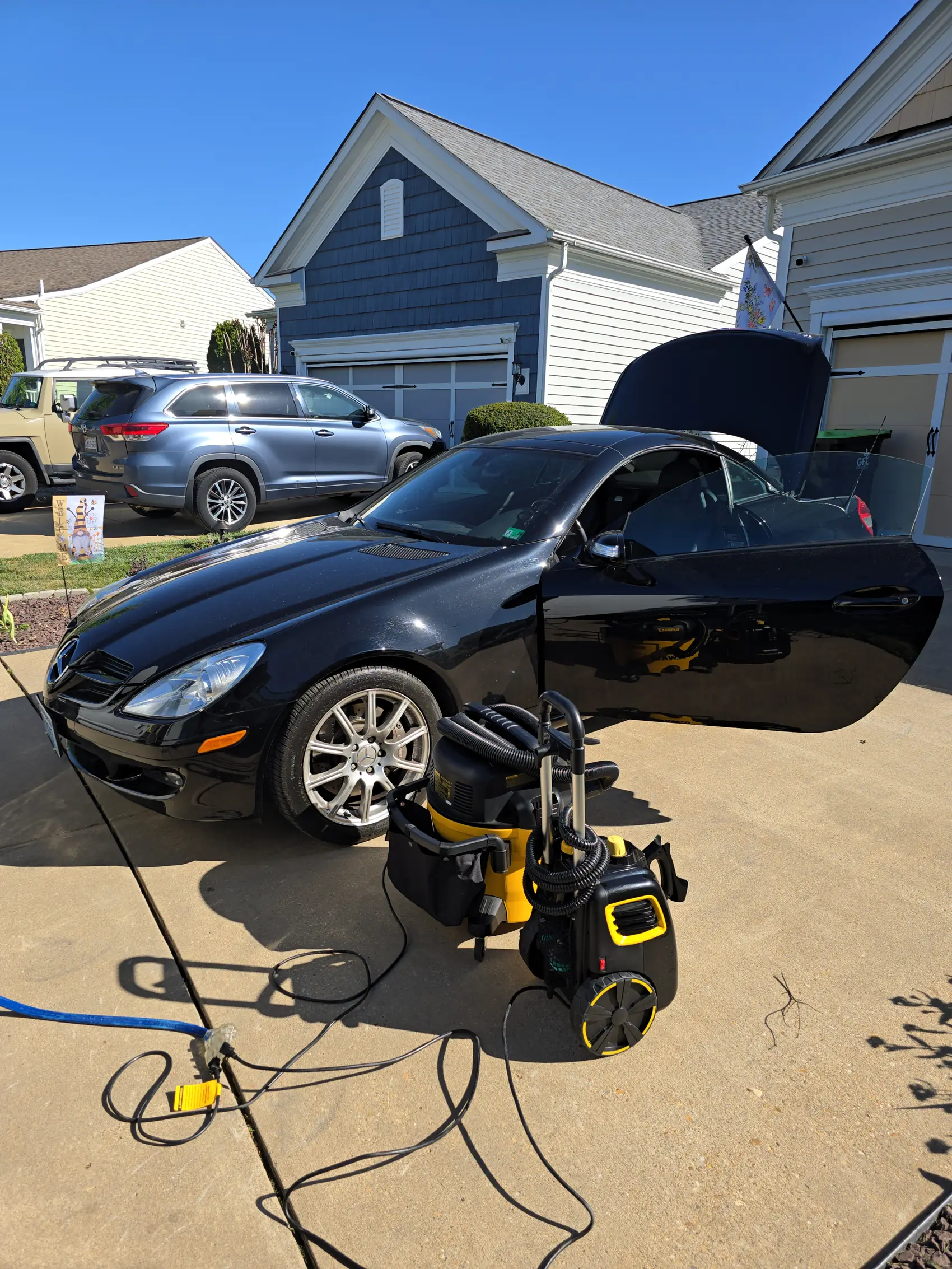 Emerald Auto Detailing equipment set up beside a black Mercedes in a Fredericksburg driveway